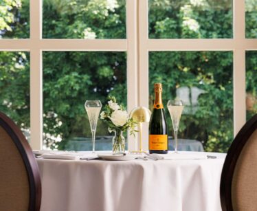 A table with a bottle of champagne and glasses on it.