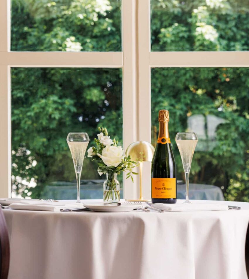 A table with a bottle of champagne and glasses on it.
