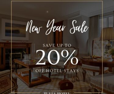 Hotel room with elegant furnishings and text overlay: "New Year Sale. Save up to 20% off hotel stays. Killarney Plaza Hotel.
