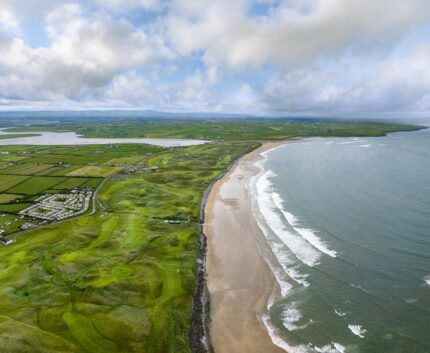 Stunning coastal view of expansive beach and lush green landscape near the hotel, perfect for a tranquil getaway.