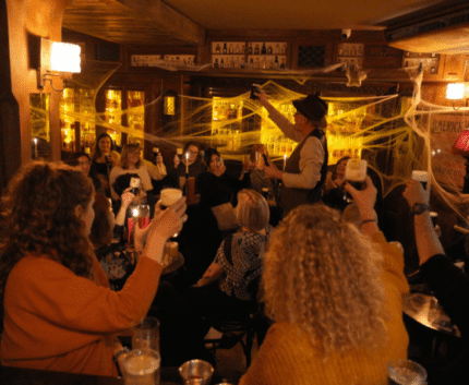 Guests enjoying lively atmosphere in hotel bar with cosy lighting, craft cocktails, and engaging entertainment.
