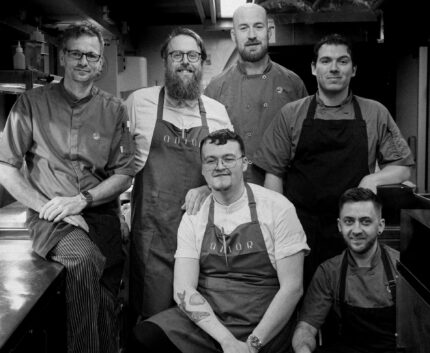 Friendly hotel chefs in modern kitchen, showcasing culinary expertise and gourmet dining experience.