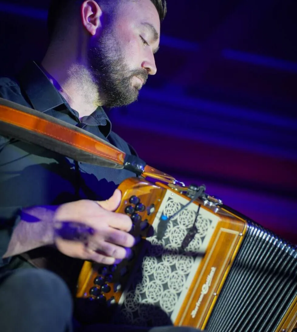 Musician playing accordion at hotel with ambient lighting, enhancing guest experience with live entertainment.