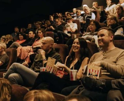 Guests enjoying a film in a cosy cinema room with plush seating and ambient lighting at our hotel.